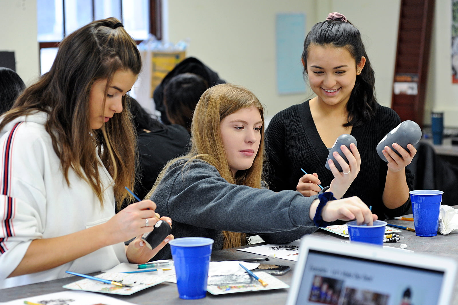 Auf dem Bild sind Schülerinnen der Lake Forest Academy in den USA zu sehen, wie sie konzentriert malen. Die Schule legt großen Wert auf die Förderung von Kreativität und ist eine ausgezeichnete Wahl für künstlerisch begabte Schüler und Schülerinnen.